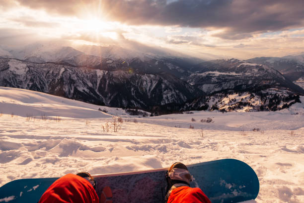istock snowboarder with snowboard is sitting on the mountain on the sunset 958427698