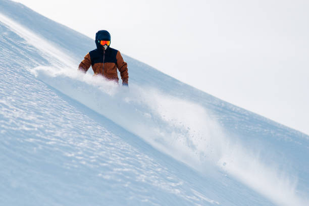 istock snowboarder is riding from snow hill 958427762