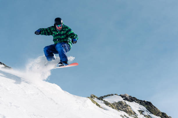 istock snowboarder is riding and jump from snow hill 958428092