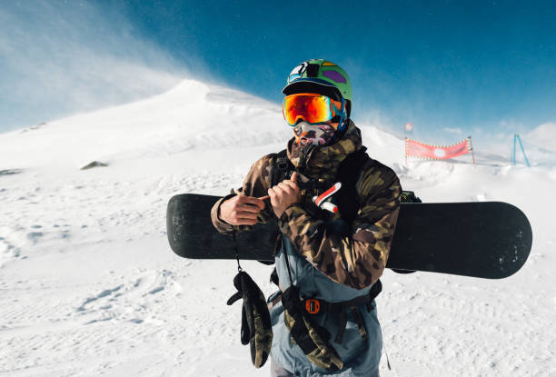 istock man stay with snowboard equipment 958428096