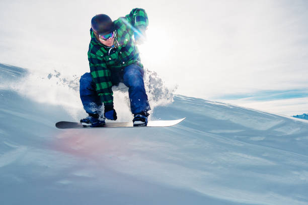 istock snowboarder is riding and jump from snow hill 958428594