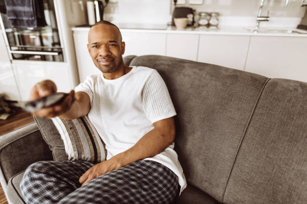 istock man watching the tv on the couch 958428948