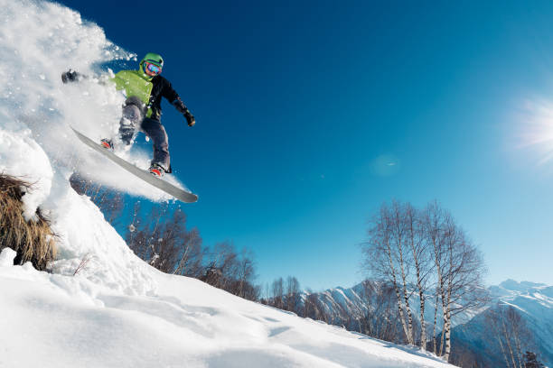 istock snowboarder is jumping with snowboard 958429318