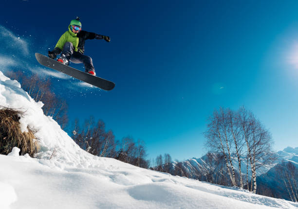 istock snowboarder is jumping with snowboard 958429346