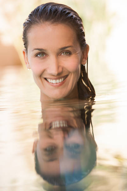 istock beautiful woman in a swimming pool 958429660