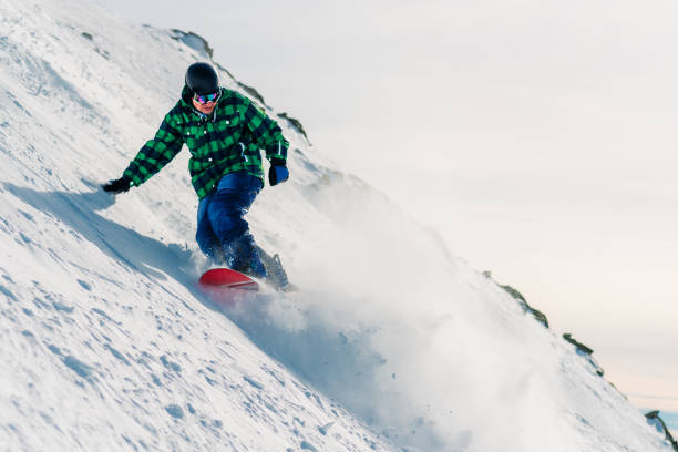 istock snowboarder is riding down from snow hill 958429684