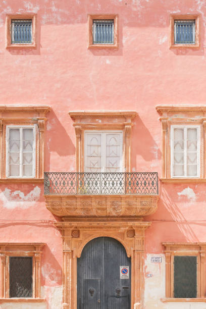 istock Gallipoli, Apulia - A pink facade with a barn door and several windows 958429852