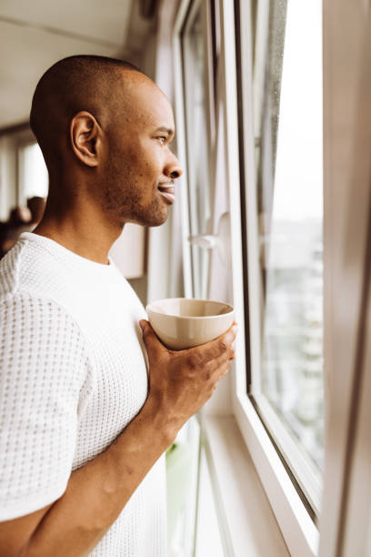 istock man doing breakfast on front of the window 958432340