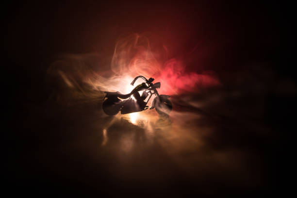 istock High power motorcycle chopper. Fog with backlights on background with man rider at night. Empty space 958433062