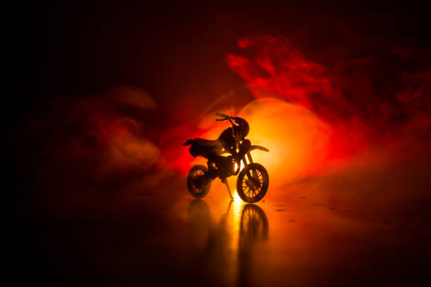 istock High power motorcycle chopper. Fog with backlights on background with man rider at night. Empty space 958433068