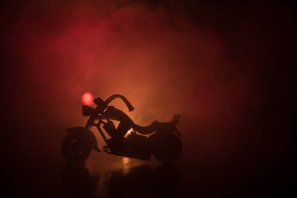 istock High power motorcycle chopper. Fog with backlights on background with man rider at night. Empty space 958433070