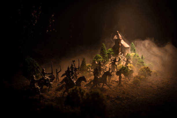 istock Medieval battle scene with cavalry and infantry. Silhouettes of figures as separate objects, fight between warriors on dark toned foggy background. Night scene. 958433084