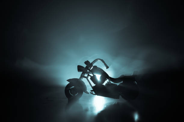 istock High power motorcycle chopper. Fog with backlights on background with man rider at night. Empty space 958433116