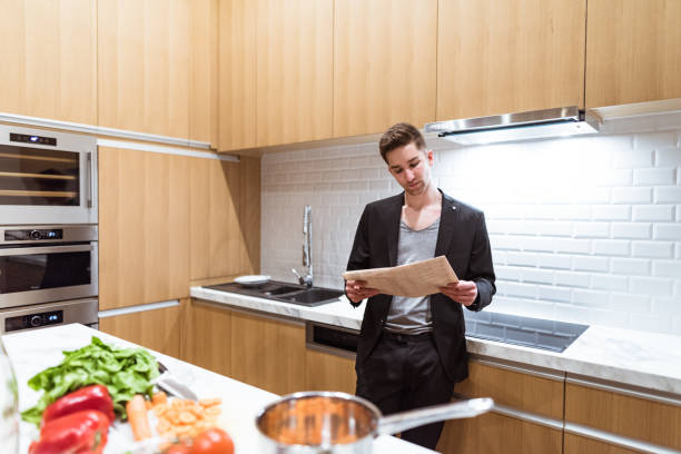 istock businessman reading the newspaper at home in the kitchen 958434308