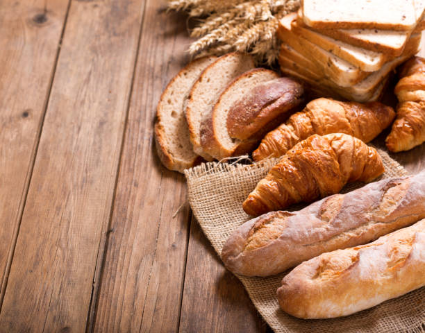 istock bread with wheat ears on wooden table 958434634
