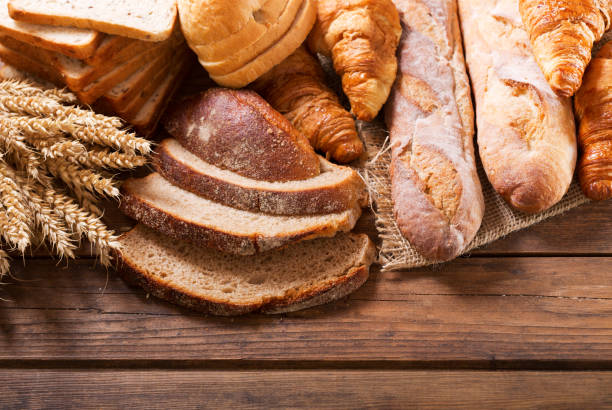 istock bread with wheat ears on wooden table, top view 958434652
