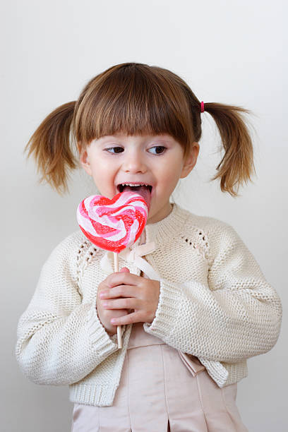 キャンディーガールと - child valentines day candy eating ストックフォトと画像