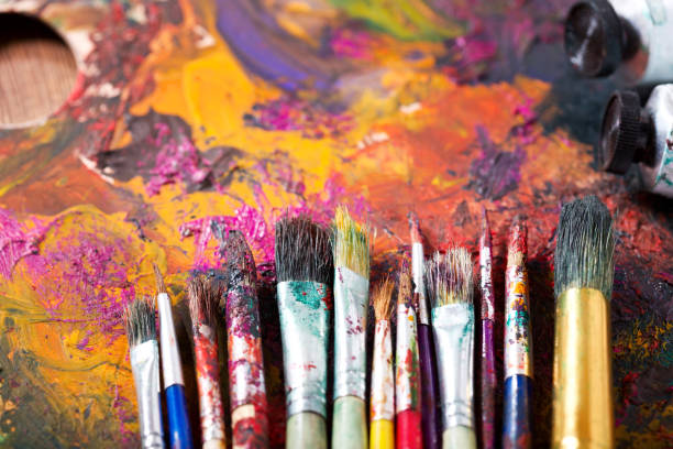 istock colorful paint brushes on a palette 958435812