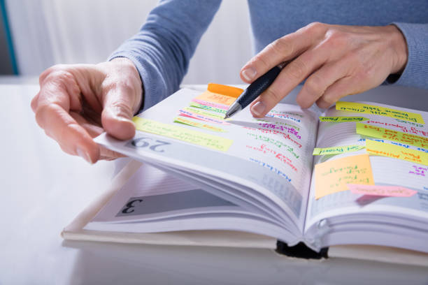 istock Woman Writing Schedule In Calendar Diary On White Desk 958437592