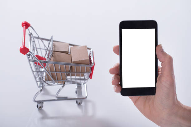 istock Cart Filled With Boxes And Hand Holding Mobile Phone 958437598