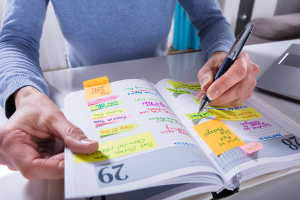 istock Woman Writing Schedule In Calendar Diary On White Desk 958437600