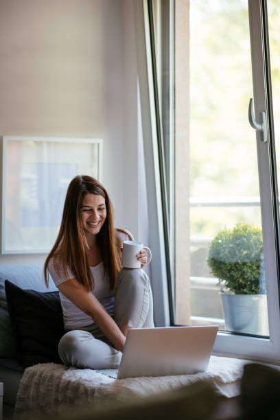 istock Beautiful female working on lap top and drinking tea 958438626