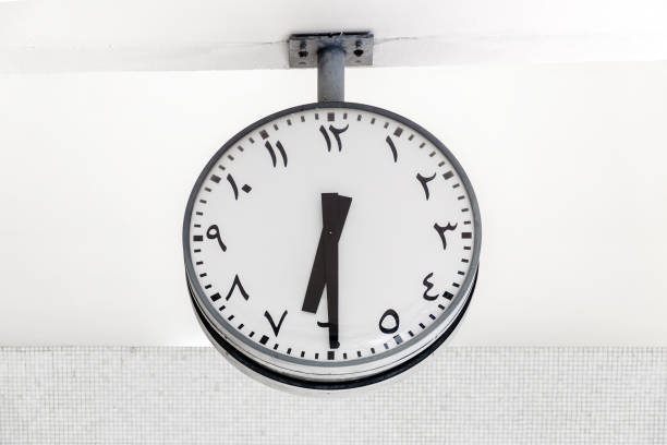 Modern clock round shape with Arabic circulars on dial and hands, showing the time 6: 30.