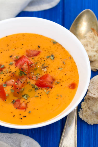 istock tomato soup in white bowl on wooden background 958451388