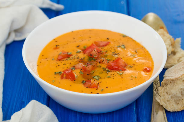 istock tomato soup in white bowl on wooden background 958451392