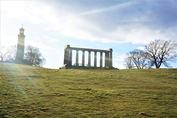 sole su calton hill edimburgo e monumento nazionale - il monumento di nelson foto e immagini stock