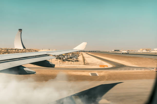 plane land - fast commercial airplane with passengers landing on the airport runway with speed and dust - fog desert arabia sunset imagens e fotografias de stock