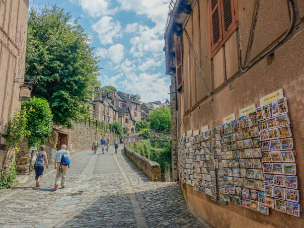 Conques, Midi Pyrenees, France - July 31, 2017: Main street of the beautiful medieval village of Conques with some people walking, France
