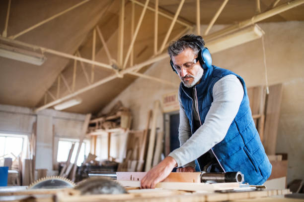 istock A man worker in the carpentry workshop, working with wood. 958462056