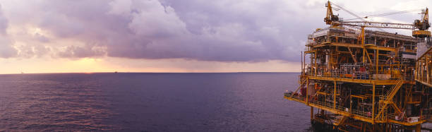 offshore de petróleo e gás do equipamento plataforma com lindo pôr do sol tempo com tempestade de nuvens no golfo da tailândia para a exibição de panorama empresarial conceito industrial. - oil pumping unit at sunset time - fotografias e filmes do acervo