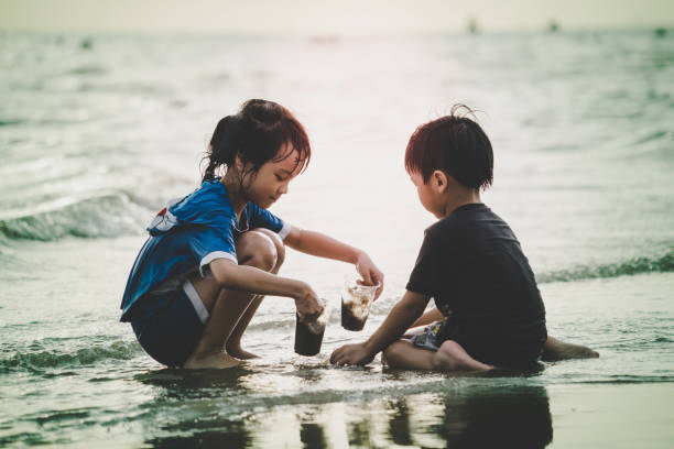 istock Boy and girl are having fun on Summer beach with sunlight 958464886