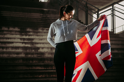 Fitness woman with UK flag. Shallow DOF. Developed from RAW; retouched with special care and attention; Small amount of grain added for best final impression. 16 bit Adobe RGB color profile.