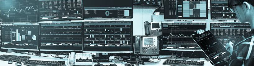 Double exposure of business woman holding tablet for Stock market quotes and chart in monitor computer room with business office equipments .business and money trading concept,panorama photo.
