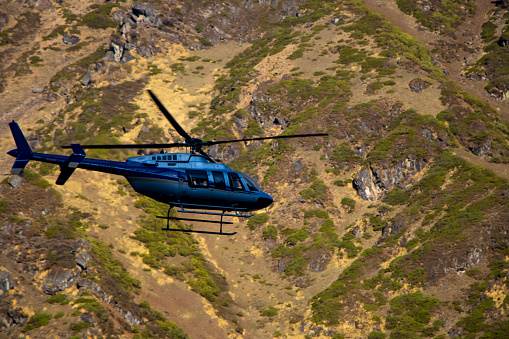 Image of a helicopter flying on a mountain area