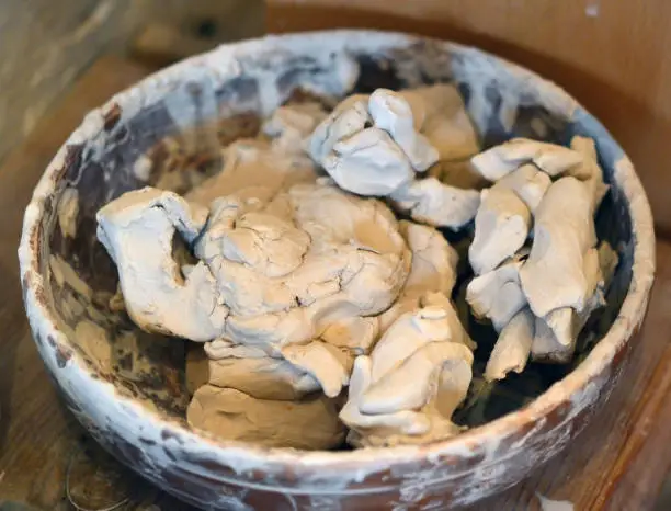 Photo of Wet white clay closeup. Abstract pieces of wet clay on the table