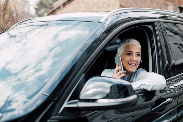 istock Senior woman using phone in a car 958471444