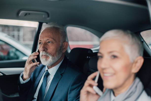 istock Business people using phones in car 958473078