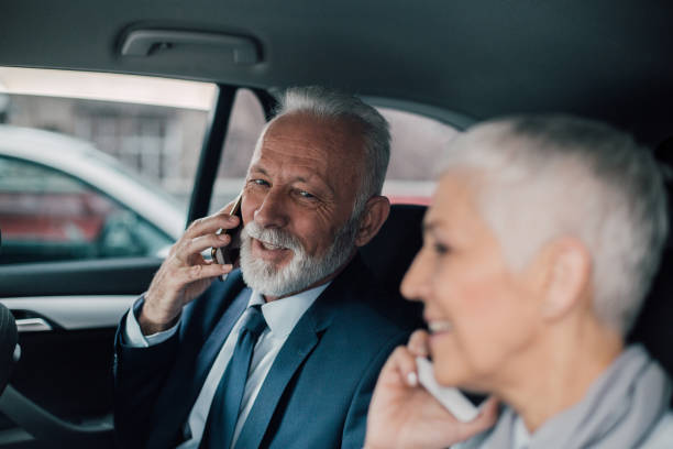 istock Mature couple using mobile phones in a car 958473080