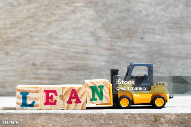 Toy Forklift Hold Letter Block N To Complete Word Lean On Wood Background Stock Photo - Download Image Now