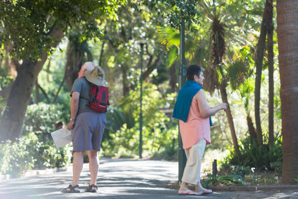 10/27 2019 - Varna, Bulgaria -  Two older people taking a walk in the city park, outdoors, autumn season with fallen leaves on the ground