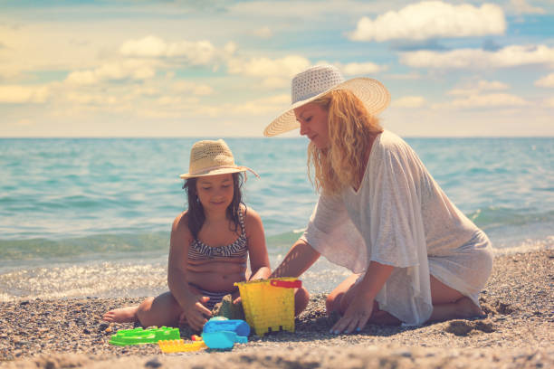 istock Young Mother And Daughter Relaxing At The Beach 958479864