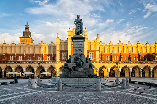 Adam Mickiewicz Monument and renaissance Cloth Hall Sukiennice  and Town Hall tower in the Main Market Square of Krakow, Poland