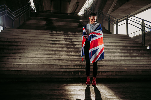 Female UK athlete with national flag. Shallow DOF. Developed from RAW; retouched with special care and attention; Small amount of grain added for best final impression. 16 bit Adobe RGB color profile.