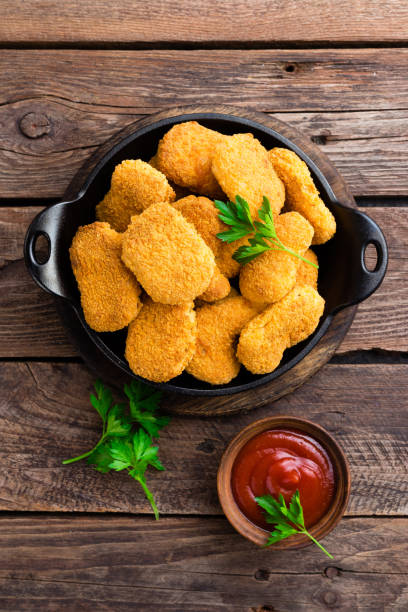 Nuggets. Chicken nuggets with ketchup on wooden table. Fast food Nuggets. Chicken nuggets with ketchup on wooden table. Fast food nugget photos stock pictures, royalty-free photos & images