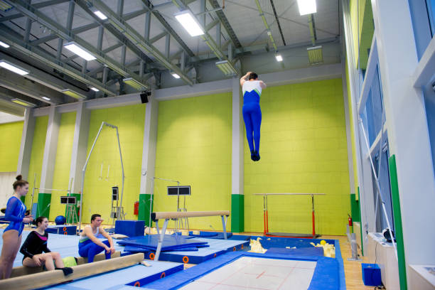istock Young Adult Gymnastics Athletes Practicing on Trampoline 958492530