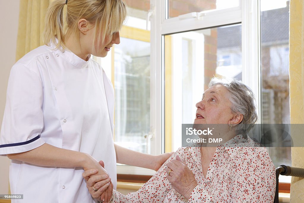 Primer plano de enfermería charlar a senior mujer en silla de ruedas - Foto de stock de Adulto libre de derechos
